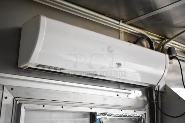 Air conditioning unit inside 2019 Cruising Kitchens trailer. Visible wear on casing. Positioned above the trailer's metallic interior.