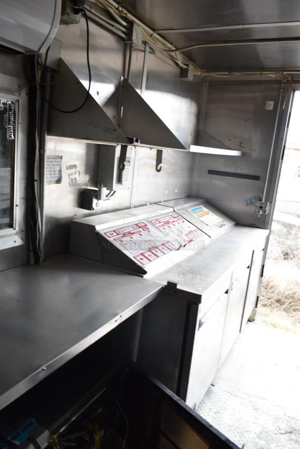 2019 Cruising Kitchens 8.5' x 24' trailer interior showing CaptiveAire grease hood, fire suppression system, and stainless steel prep area.