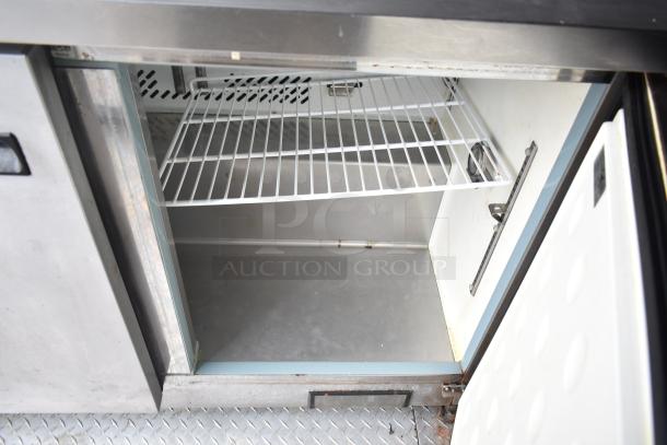 Interior view of Arctic Air cooler in 2019 Cruising Kitchens trailer, featuring wire shelving and clean metallic finish.