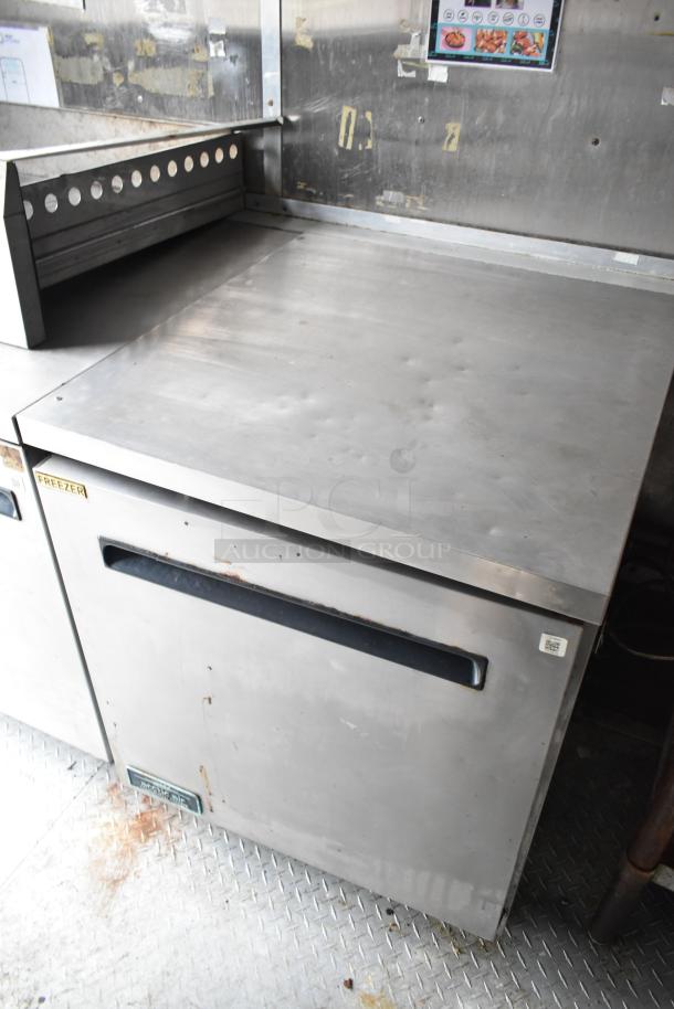 2019 Cruising Kitchens trailer interior showing Arctic Air freezer, stainless steel countertop, and visible wear.