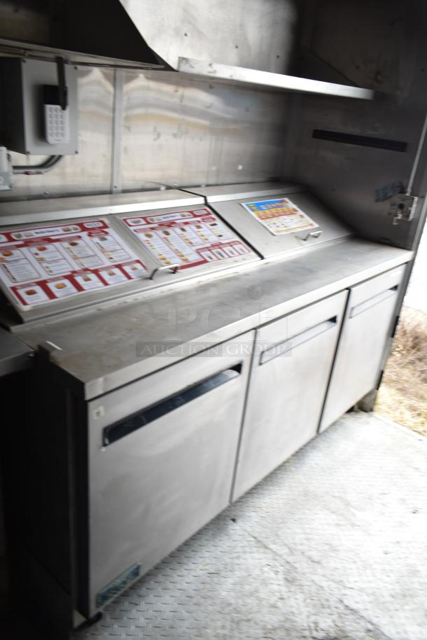 2019 Cruising Kitchens trailer interior with Arctic Air prep tables. Equipped with CaptiveAire grease hood and fire suppression.