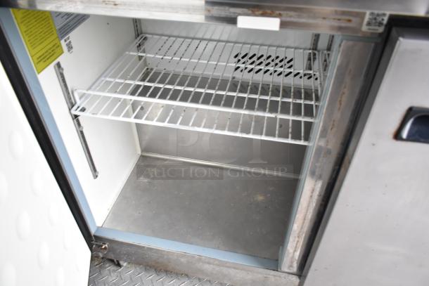 Interior view of Arctic Air cooler from 2019 Cruising Kitchens trailer. Metal shelving, slight wear visible.