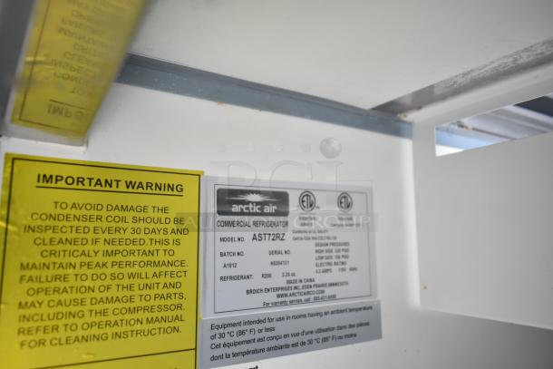 Arctic Air commercial refrigerator label and warning sign inside Cruising Kitchens trailer, emphasizing maintenance instructions.