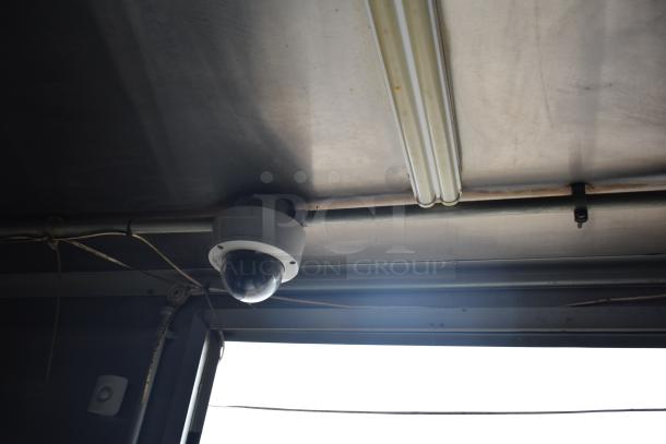 Ceiling view inside a 2019 Cruising Kitchens trailer with a dome security camera and fluorescent lighting fixture.