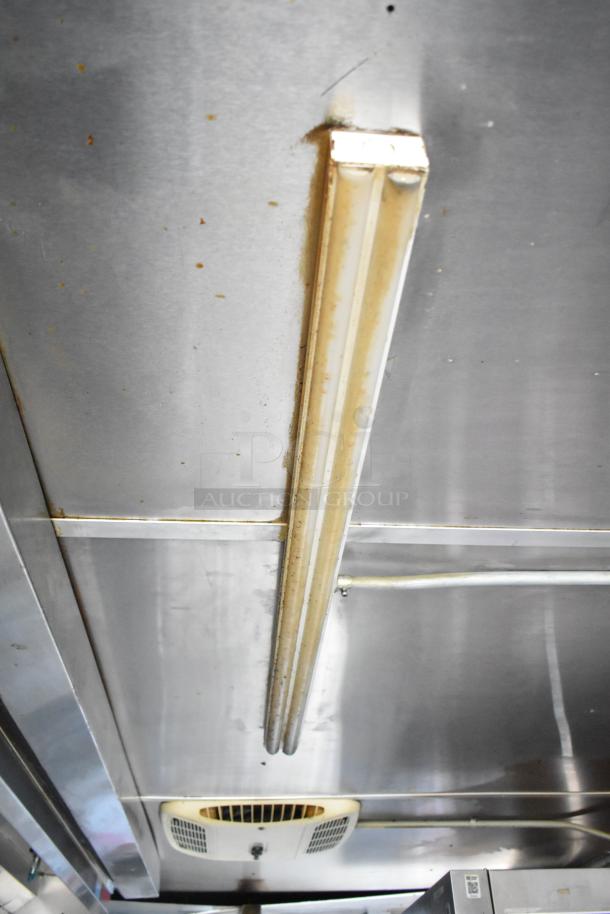 Interior ceiling of a 2019 Cruising Kitchens trailer, showing metal panels and a light fixture. Visible wiring on the ceiling.