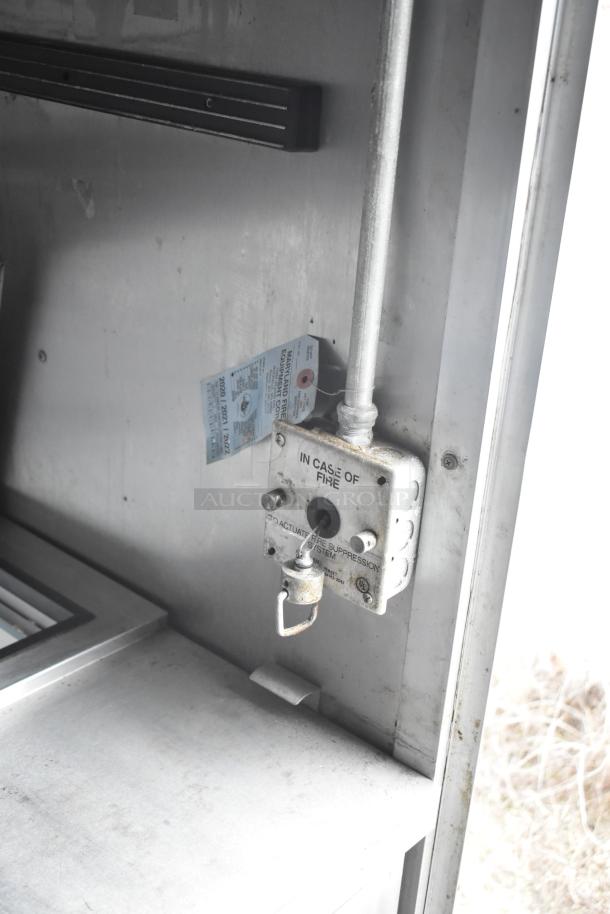 Fire suppression system detail in 2019 Cruising Kitchens trailer. "In Case of Fire" label, activation mechanism visible.