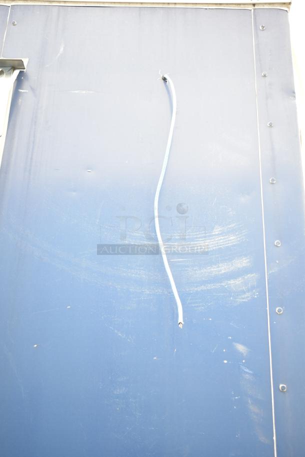 Blue side panel of 2019 Cruising Kitchens 8.5' x 24' trailer. Visible white cable and surface scratches.