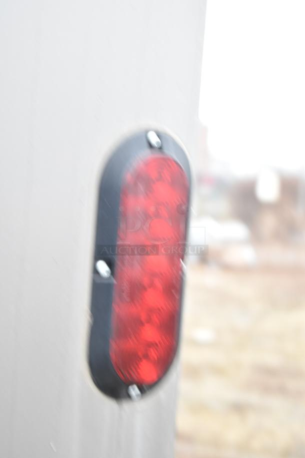 Blurred close-up of red trailer tail light on the 2021 Nationwide 8.5' x 24' food trailer shell.