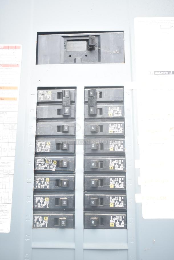Close-up of an electrical panel with multiple circuit breakers. Labels and markings include voltage ratings and safety instructions.