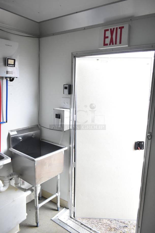 2021 Nationwide 8.5' x 24' food trailer shell interior, features a stainless steel sink, wiring, and exit sign. Ready for customization.