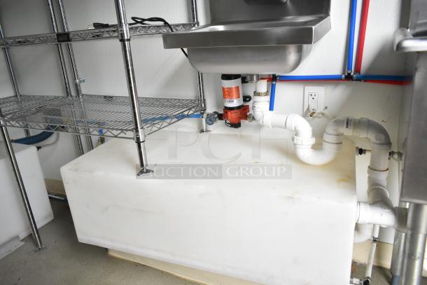 2021 Nationwide 8.5' x 24' food trailer shell interior, featuring stainless steel sink, wire shelving, and plumbing setup. Ready for customization.