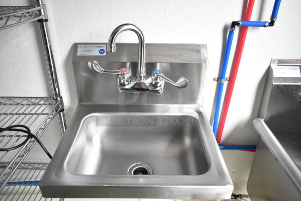 Stainless steel sink with dual handles and NSF label in a Nationwide food trailer shell. Visible wire shelving units.
