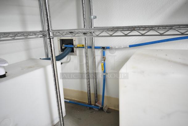 Interior view of 2021 Nationwide 8.5' x 24' food trailer shell, featuring plumbing fixtures, wire shelving, and Martin IT cabinet.