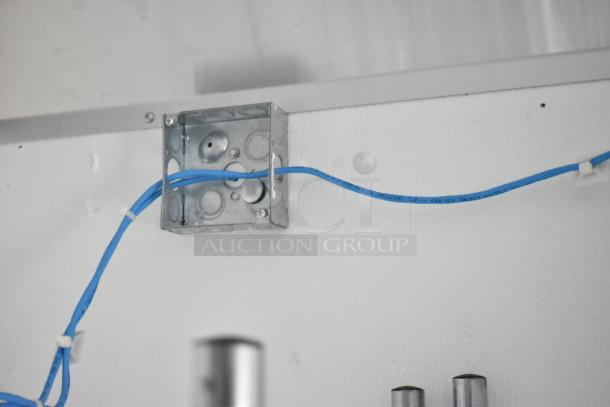 Metallic wiring box with attached blue Ethernet cable inside the Nationwide 8.5' x 24' food trailer shell.