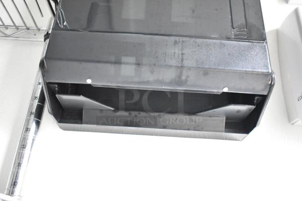 Black wire shelving and paper towel dispenser in a clean, white interior. Part of a 2021 Nationwide 8.5' x 24' food trailer shell.