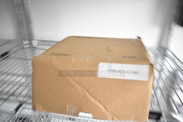 Blurry image of a cardboard box labeled "PHI-421-GVII" on a wire shelf.