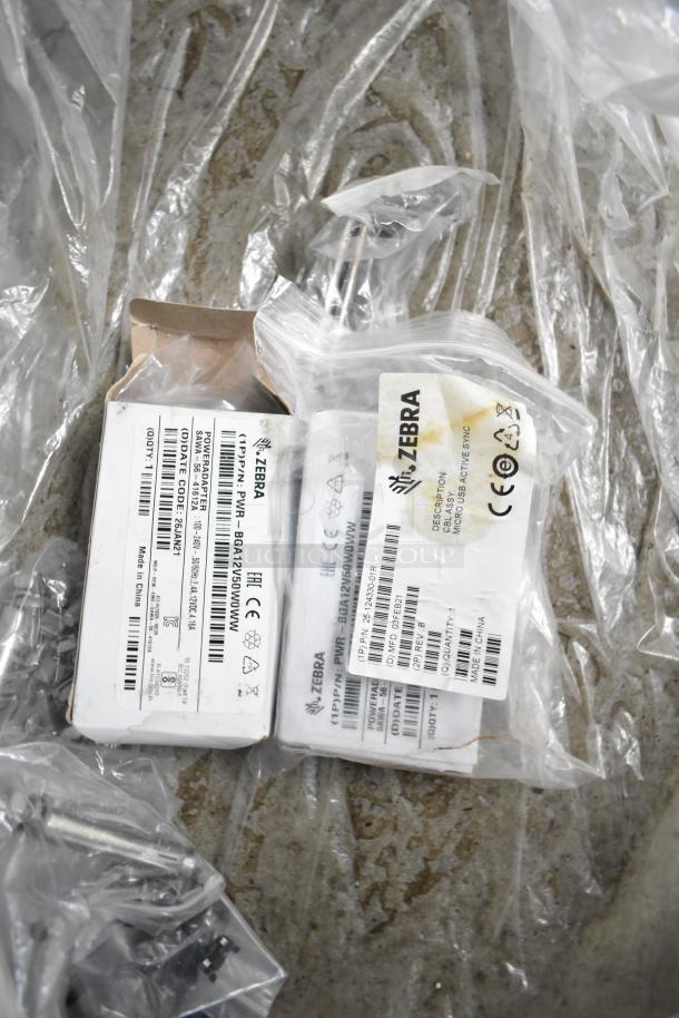 Plastic-wrapped Zebra products with labels showing model numbers and "Made in China" markings on a textured surface.