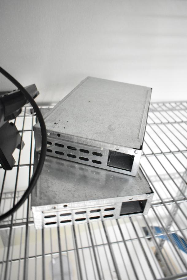 Metal components on wire shelving inside 2021 Nationwide 8.5' x 24' food trailer shell, ready for equipment installation.