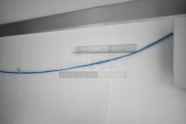 Interior view of a 2021 Nationwide 8.5' x 24' food trailer shell, ready for customization, featuring wire shelving units.