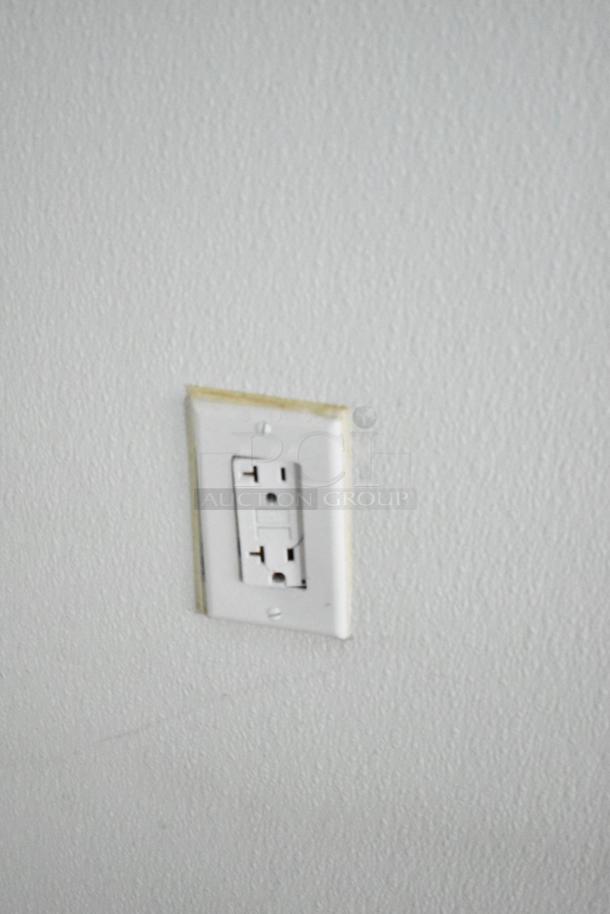 A white electrical outlet on a textured wall.