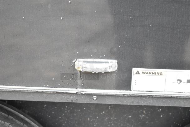 2020 SDG 8.5' x 20' food trailer shell, exterior close-up with side light and warning label. Ready to be equipped.