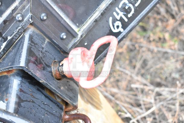 Red tow hitch detail on a black SDG food trailer shell. Note model number marking in white ink on the surface.