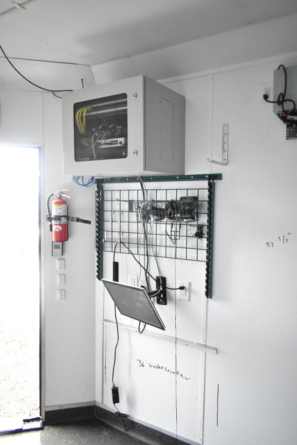 2020 SDG 8.5' x 20' food trailer shell interior, featuring a Martin IT/Network cabinet, wire shelving, and fire extinguisher.