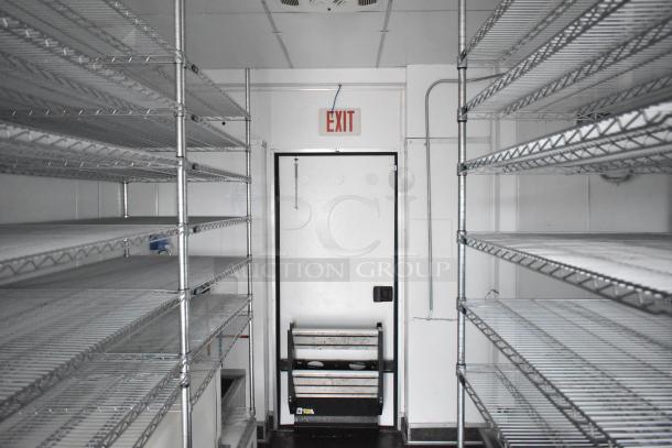 2020 SDG 8.5' x 20' food trailer shell, equipped with wire shelving units and Martin IT/Network Cabinet, ready for customization.