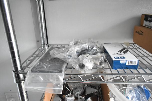 Metal wire shelf holding packaged hardware and a Cradlepoint network device box, part of a 2020 SDG food trailer shell setup.