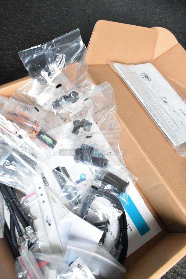 Assorted installation and networking hardware in plastic packaging inside a cardboard box for SDG 8.5' x 20' food trailer shell.