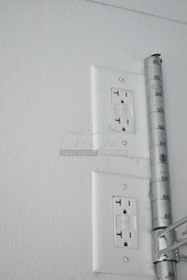 Electrical outlets and a metal height measurement strip inside the SDG 8.5' x 20' food trailer shell, ready for customization.