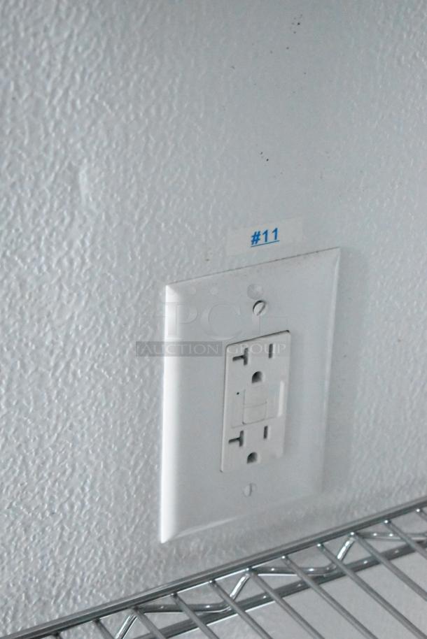 Interior of SDG 8.5' x 20' food trailer shell, metal wire shelving, GFCI outlet, label marked "#11."