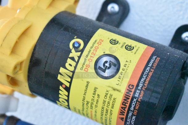 Yellow Flow-Max pump with DS-01230-D2 model label by Lippert Components. Usage and safety instructions visible.