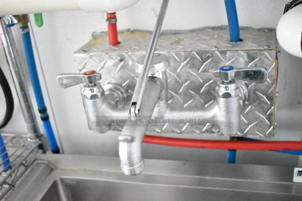 2020 SDG 8.5' x 20' food trailer faucet and plumbing with red and blue pipes. Diamond plate backsplash.