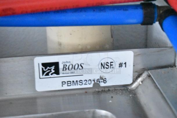 Label showing John Boos PBMS2016-6, NSF certified sink. Stainless steel surface with red and blue piping overhead.