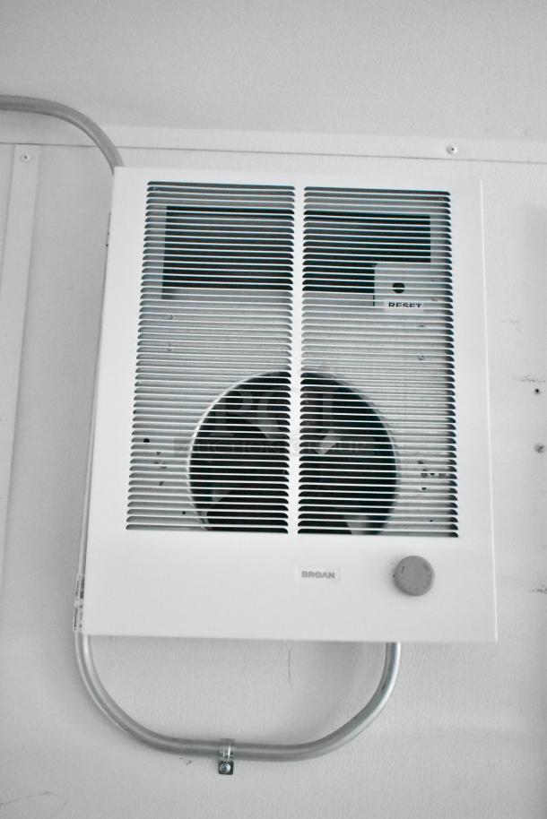 Wall-mounted Broan electric heater, white, with reset button and control knob, mounted on a white wall.