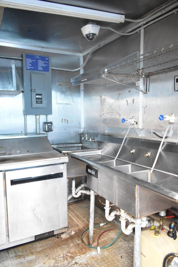 2019 Cruising Kitchens food trailer interior with Arctic Air cooler, triple sink, and Avigilon camera. Label displays "WASH."