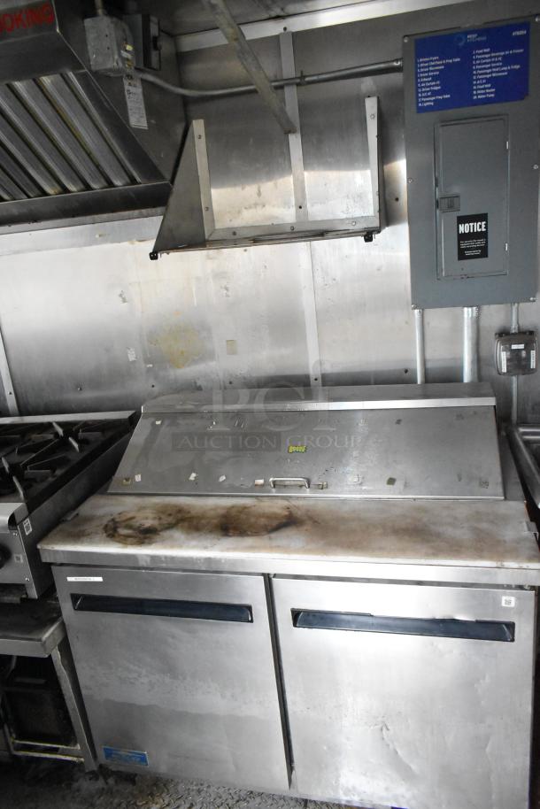 2019 Cruising Kitchens trailer interior with CaptiveAire grease hood, Arctic Air prep tables, and coolers; visible wear.