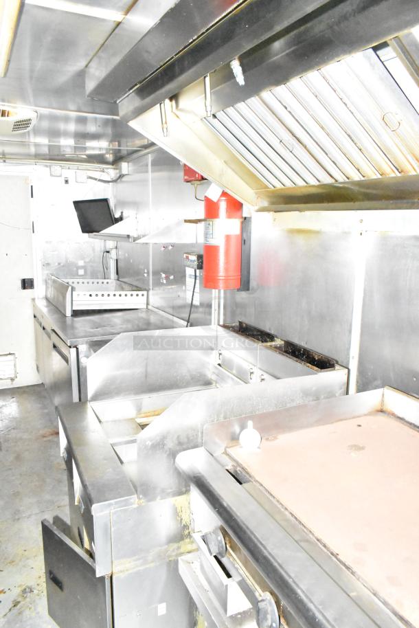 2019 Cruising Kitchens trailer interior with CaptiveAire grease hood, fire suppression, Arctic Air prep tables, and coolers.