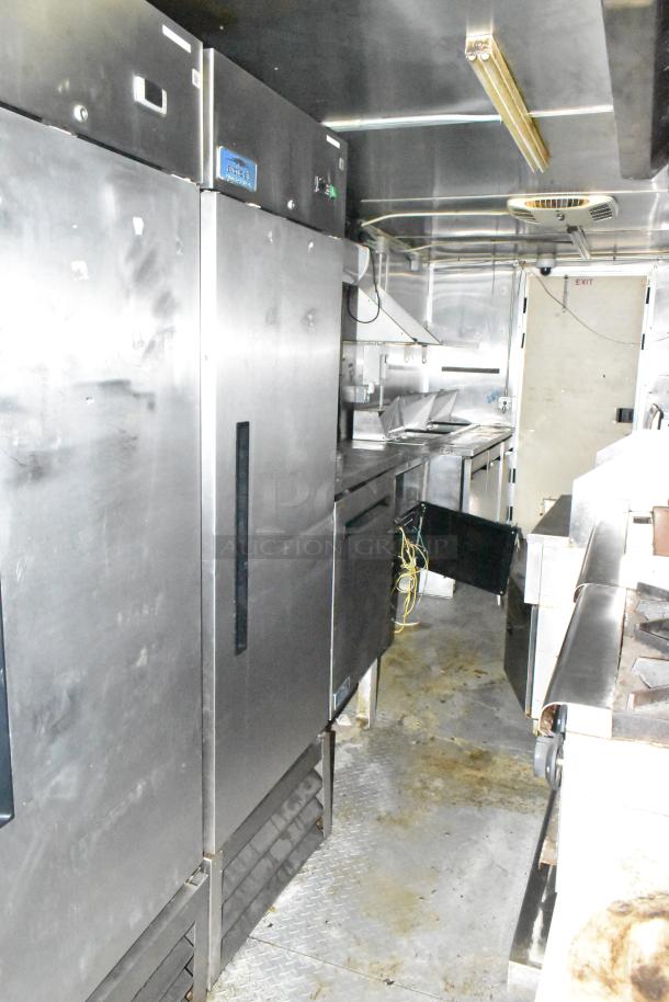 2019 Cruising Kitchens trailer interior with stainless steel Arctic Air coolers, prep tables, CaptiveAire hood, network cabinet.