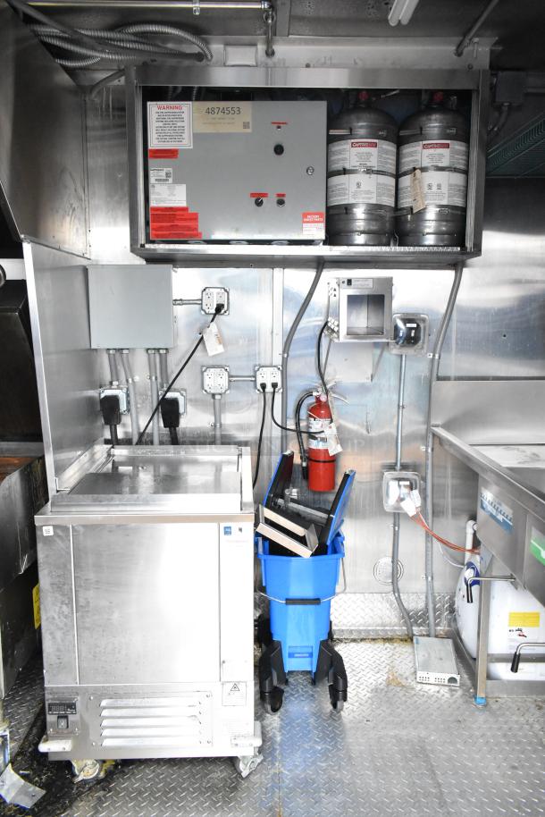 2021 Titanium Cargo 8.5' x 28' mobile kitchen trailer interior, showing electrical panel, fire extinguisher, and equipment setup.