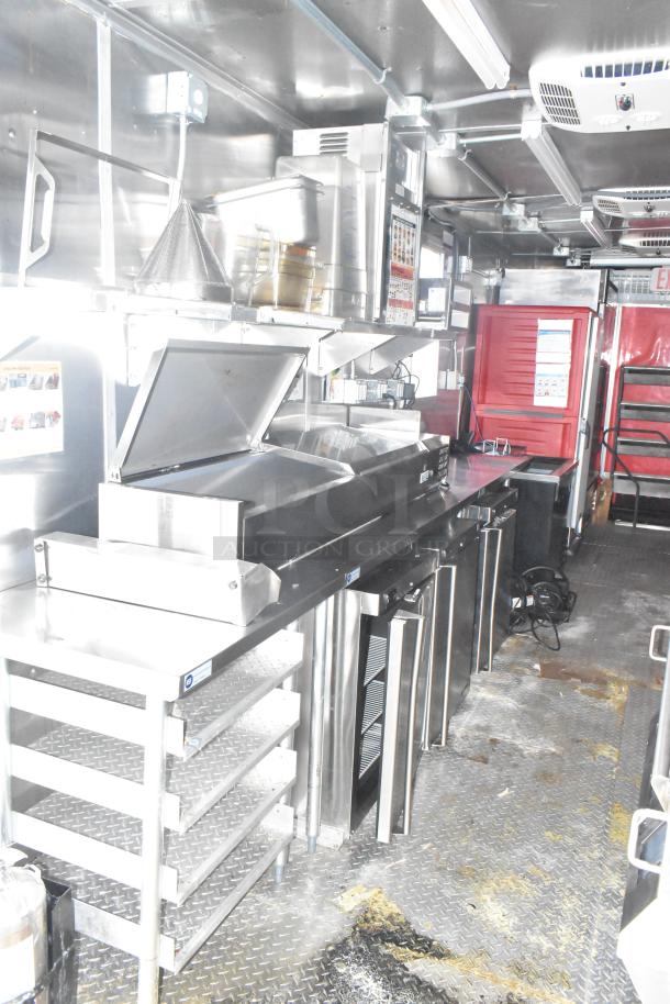 2021 Titanium Cargo mobile kitchen trailer interior with Garland clamshell griddle, refrigeration units, and stainless steel counters.