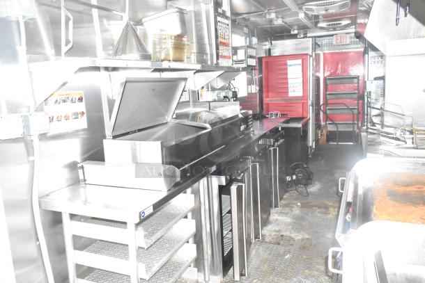 2021 Titanium Cargo 8.5' x 28' mobile kitchen trailer interior, featuring Henny Penny fryer, Taylor soft serve, Garland griddle, full refrigeration, and CaptiveAire hood.