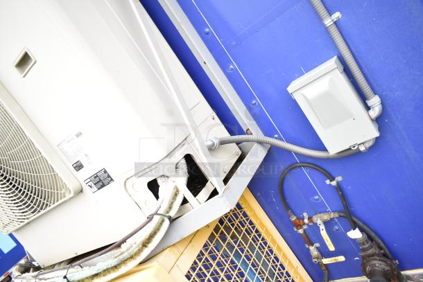 Exterior view of Burger King mobile kitchen trailer showing wiring and plumbing. Features air conditioning unit.