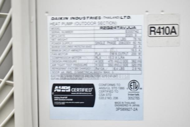 Blurry label on Daikin Industries heat pump. Shows model, serial number, manufacturing date, and specifications.