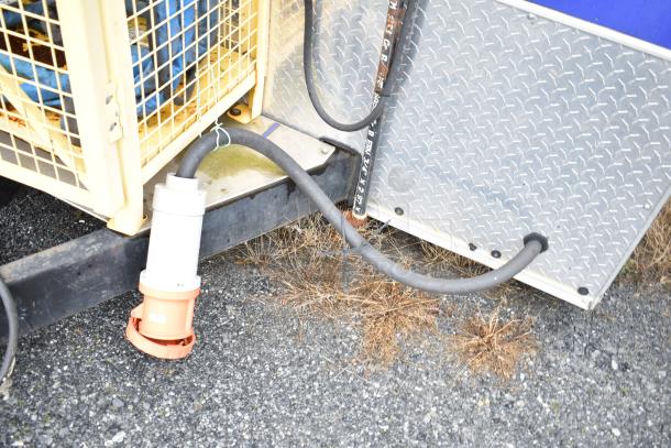Mobile kitchen trailer wiring connection and power cable setup on gravel ground; part of a fully outfitted Burger King spec kitchen.