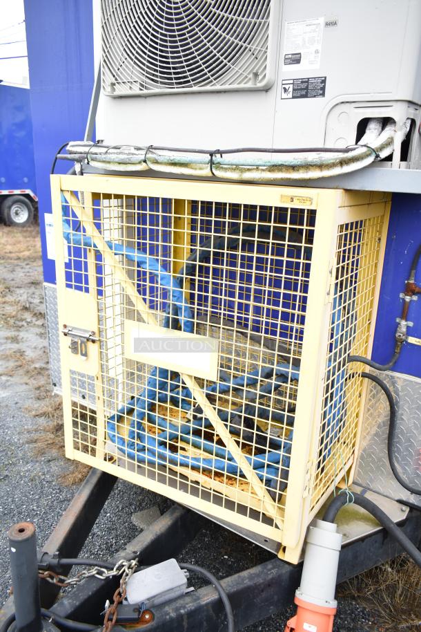 Auction item image of a Burger King mobile kitchen trailer with attached equipment enclosure, cables, and air conditioning unit.