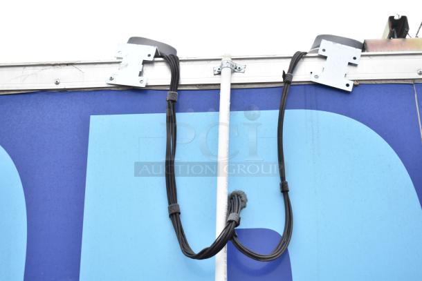 Alt text: Exterior view of a mobile kitchen trailer corner, showing attached cables and mounting brackets.