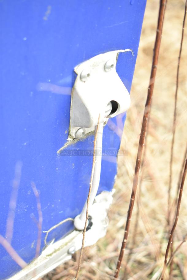 Blue exterior of mobile kitchen trailer showing a metal connector with cable attachment.