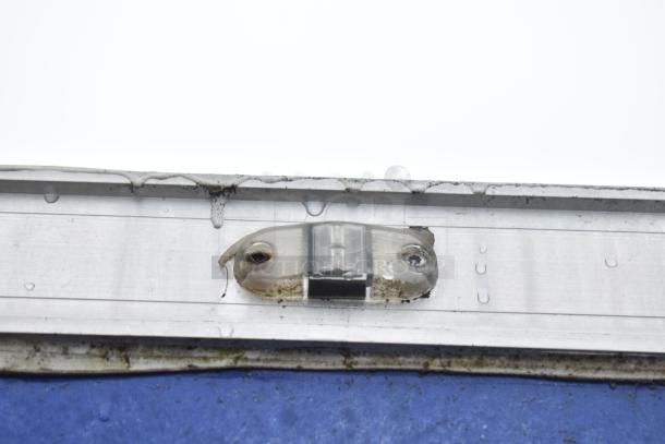 Roof detail of a mobile kitchen trailer showing a weathered light fixture; condition suggests outdoor use.